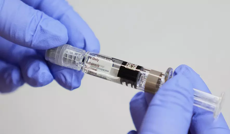 Pentagon ends flu vaccine mandate: Medical worker holding syringe for flu vaccination in clinic