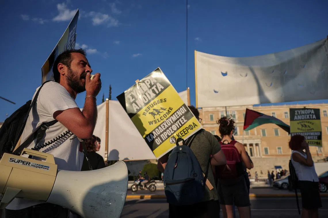 Greece migrant return hubs plan protest outside parliament in Athens