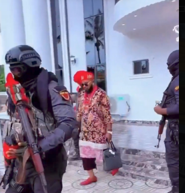Man in Igbo attire with guards